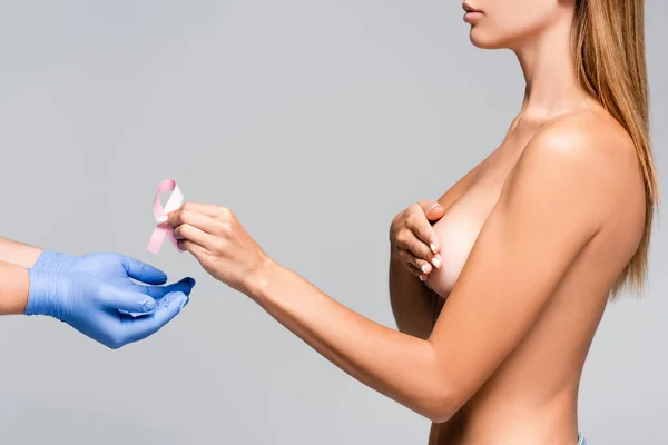 戴乳胶手套的医生近于裸体女性 带着灰色的乳腺癌意识带的剪影 — 图库照片