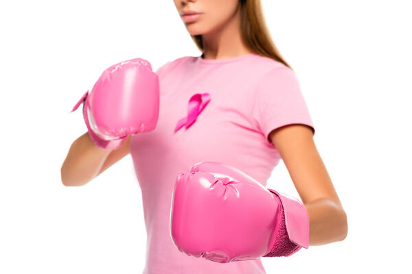 Cropped view of woman in boxing gloves and pink ribbon of breast cancer on blurred background isolated on white
