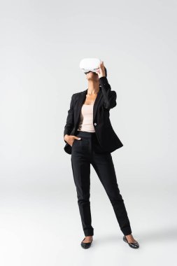 VR kulaklıklı Afro-Amerikan iş kadını beyazlar içinde izole edilmiş.