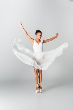 graceful african american ballerina in dress dancing on white background clipart