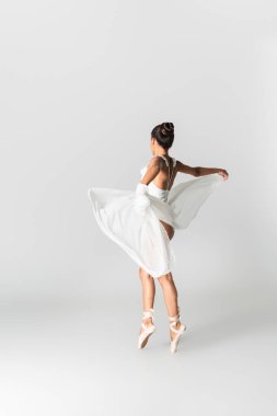 Beyaz arka planda dans eden zarif Afrikalı Amerikalı balerin.
