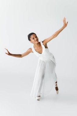 Zarif Afro-Amerikan balerin beyazlar üzerinde dans ediyor.