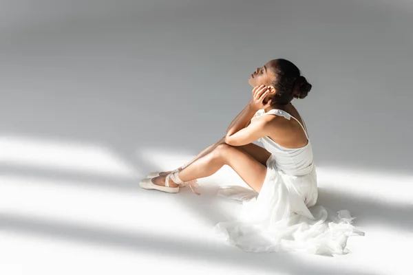 Elegante Bailarina Afroamericana Vestido Sentado Suelo Sobre Fondo Blanco — Foto de Stock