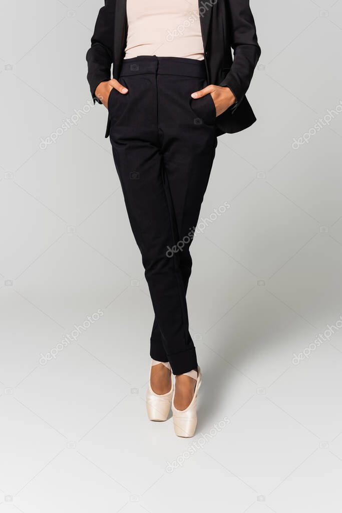 cropped view of african american businesswoman in pointe shoes isolated on grey