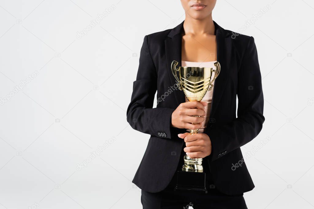 cropped view of african american businesswoman with golden cup isolated on grey