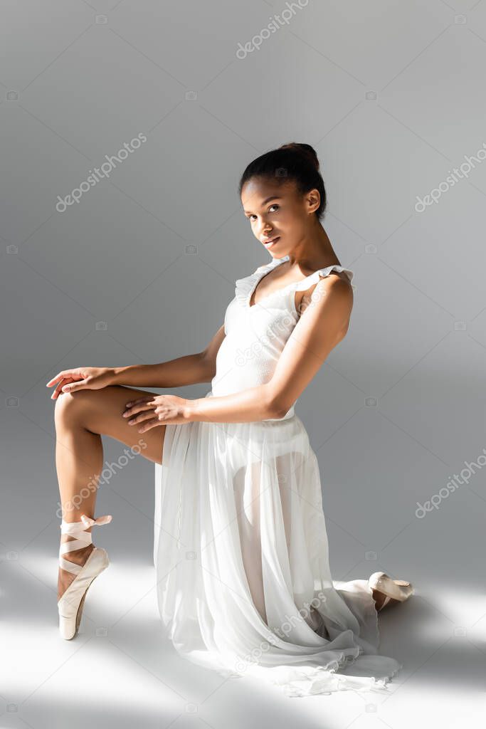 graceful african american ballerina in dress on white background