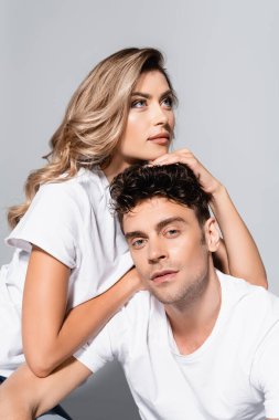 Gri tişörtlü genç çift izole edilmiş bir şekilde kucaklaşıyorlar.