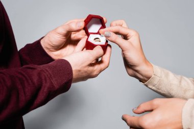 Gri yolda izole edilmiş bir kadına evlenme teklif eden adamın görüntüsü.