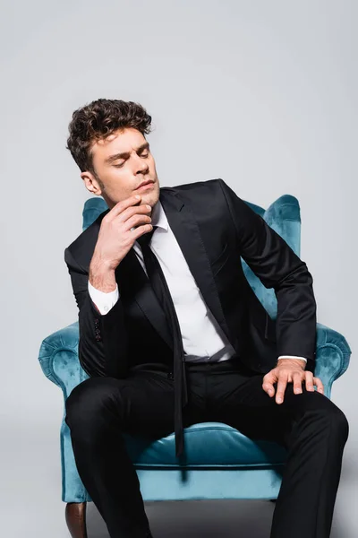 Homem Elegante Terno Sentado Poltrona Veludo Isolado Cinza — Fotografia de Stock