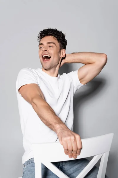 Happy Young Man White Shirt Chair Isolated Grey — Stock Photo, Image