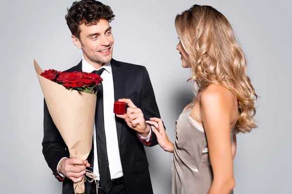 Eleganter Junger Mann Mit Blumenstrauß Macht Heiratsantrag Isoliert Auf Grau — Stockfoto