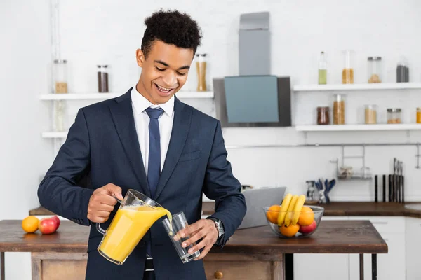 Feliz Empresário Afro Americano Segurando Jarro Derramando Suco Laranja Vidro — Fotografia de Stock