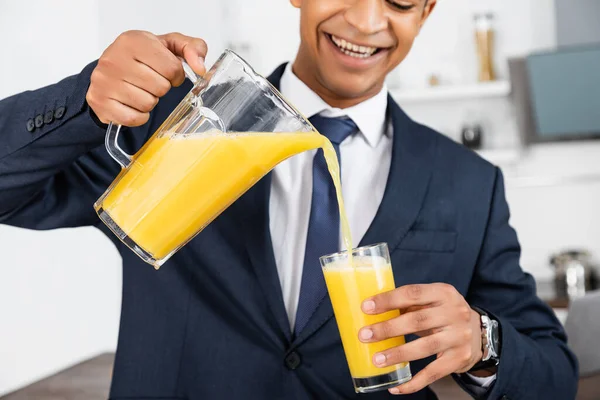 Обрізаний Вид Щасливого Афроамериканського Бізнесмена Тримає Глечик Заливає Апельсиновий Сік — стокове фото