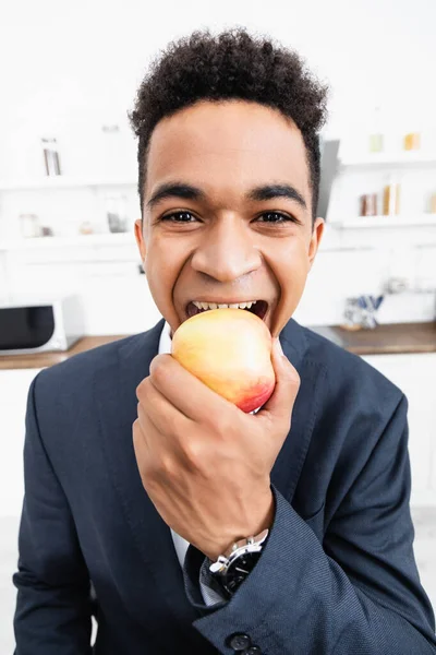 幸せなアフリカ系アメリカ人ビジネスマンがリンゴを食べて — ストック写真