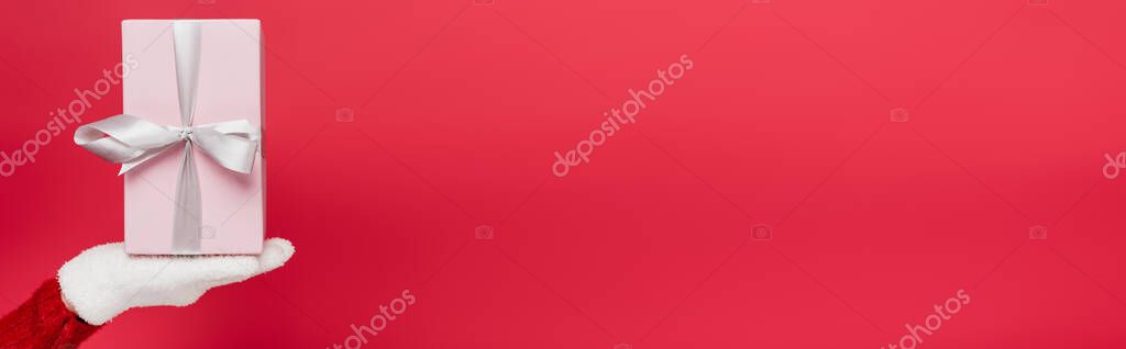 Cropped view of woman in white glove holding wrapped present isolated on red, banner — Stock Image Cropped View Woman White Glove Holding Wrapped Present Isolated Red Stock Picture
