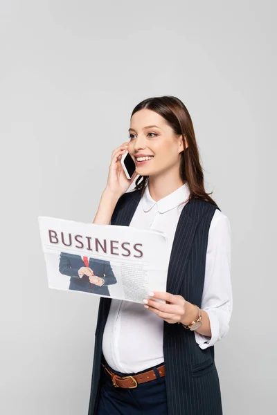 幸せな若い妊婦ビジネス新聞を保持し 灰色で隔離されたスマートフォンで話す — ストック写真