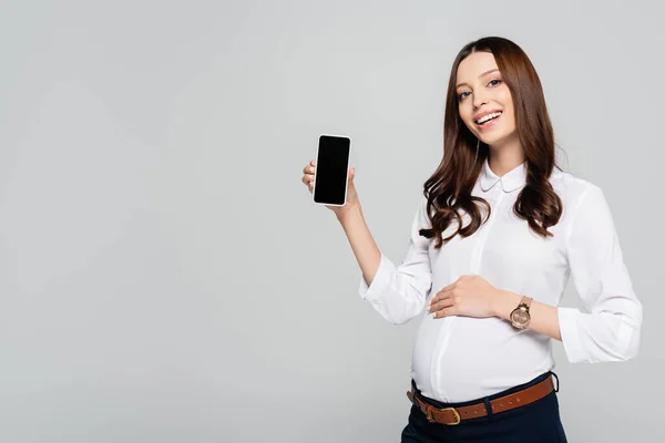 Sonriente Joven Mujer Negocios Embarazada Presentando Teléfono Inteligente Aislado Gris — Foto de Stock