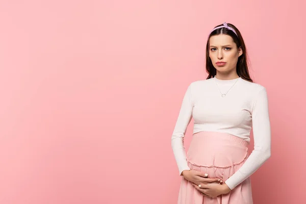Traurige Junge Hübsche Schwangere Frau Berührt Bauch Isoliert Auf Rosa — Stockfoto