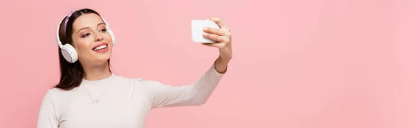 Šťastná Mladá Hezká Žena Sluchátkách Selfie Smartphone Izolované Růžové Banner — Stock fotografie