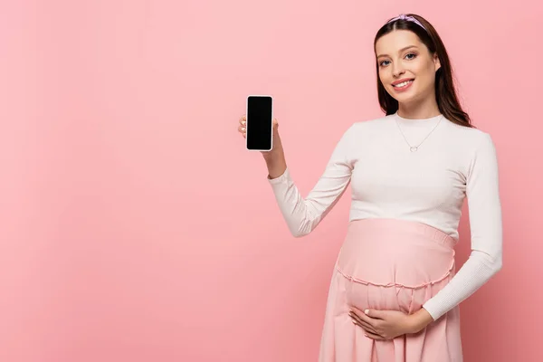 Felice Giovane Bella Donna Incinta Mostrando Smartphone Isolato Rosa — Foto Stock