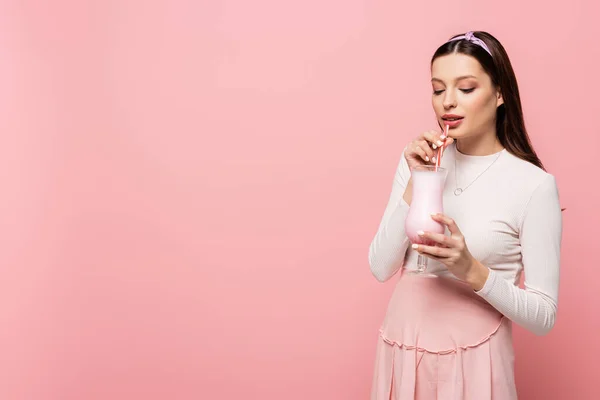 年轻漂亮的孕妇喝着用粉红隔开的奶昔 — 图库照片