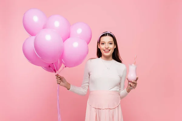 幸せな若いかなり妊娠中の女性風船とミルクシェイクがピンクに隔離され — ストック写真