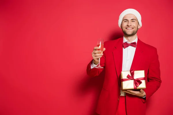 Stylish Man Santa Hat Holding Glass Champagne Present Red Background — Stock Photo, Image