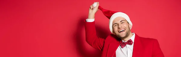 Sorrindo Homem Desgaste Formal Segurando Chapéu Papai Noel Fundo Vermelho — Fotografia de Stock