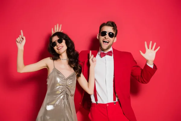 Casal Alegre Óculos Sol Gesticulando Fundo Vermelho — Fotografia de Stock