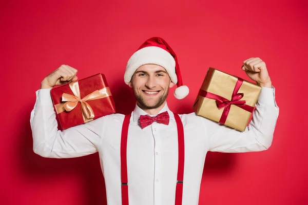 Allegro Uomo Cappello Babbo Natale Contenente Scatole Regalo Sfondo Rosso — Foto Stock