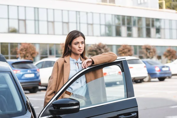 Thoughtful Young Woman Trench Coat Looking Away While Leaning Car — Stock Photo, Image