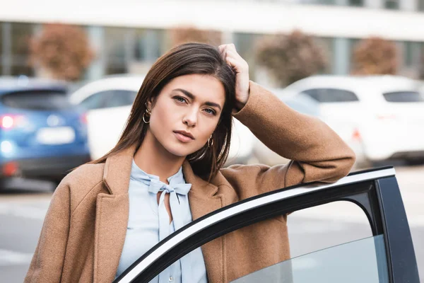 Verträumte Junge Frau Blickt Die Kamera Während Sie Sich Autotür — Stockfoto