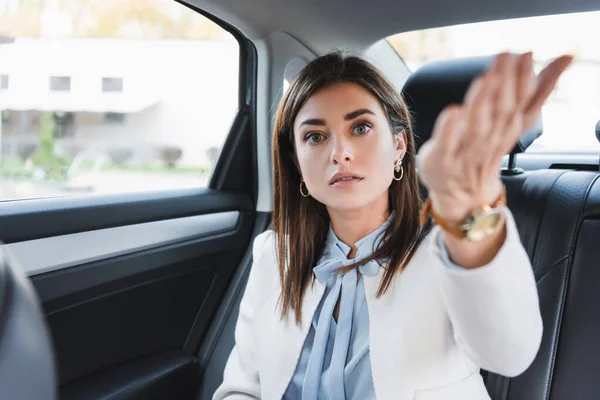 Wanita Elegan Menunjuk Dengan Tangan Sambil Duduk Kursi Belakang Mobil — Stok Foto