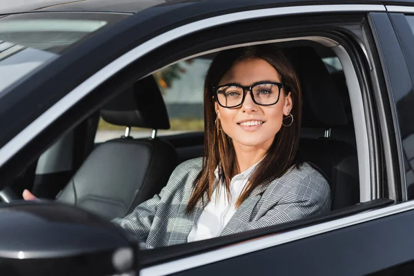 Mulher Negócios Sorridente Óculos Olhando Para Câmera Enquanto Dirige Carro — Fotografia de Stock