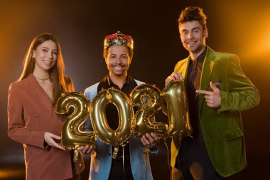 Mutlu Afro-Amerikan adam elinde balonlarla 2021 numaralı balonları tutuyor. 