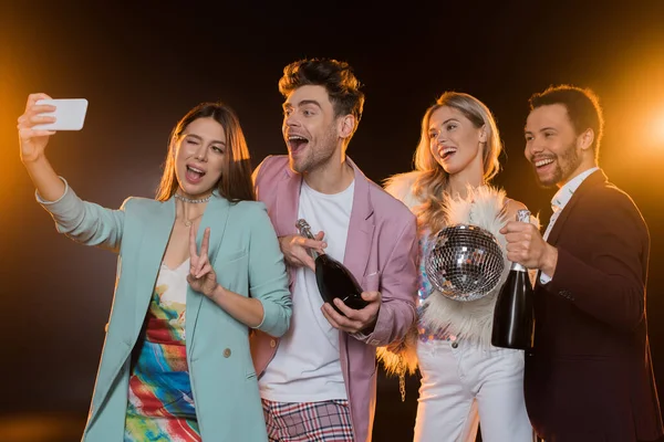 Happy Multicultural Men Holding Bottles Champagne Women While Taking Selfie — Stock Photo, Image