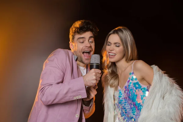 Man Blonde Woman Singing While Holding Microphone Black — Stock Photo, Image