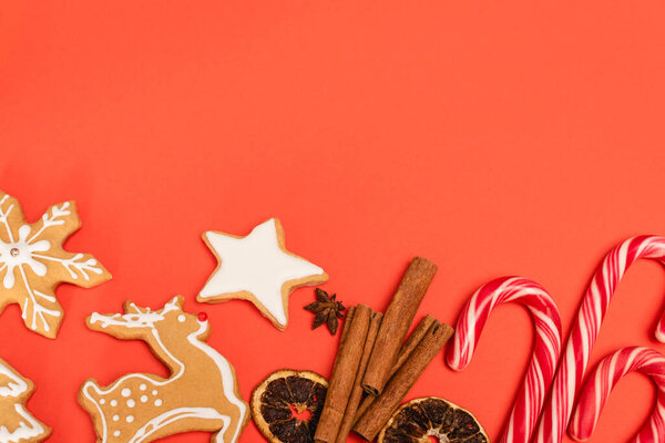 верхний вид конфеты трости, специи и пряники печенье на красном фоне
