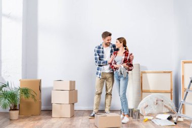 Evdeki kutuların yanında birbirine bakan mutlu genç bir çift.