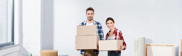 Sonriente Joven Pareja Con Cajas Mirando Cámara Interior Pancarta — Foto de Stock