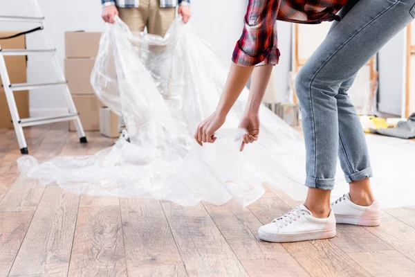 Cropped View Young Couple Polyethylene Covering Floor Home Blurred Background — Stock Photo, Image