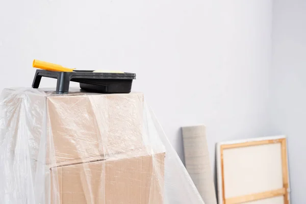 Farbroller Mit Tablett Auf Boxen Mit Polyethylen Auf Verschwommenem Hintergrund — Stockfoto