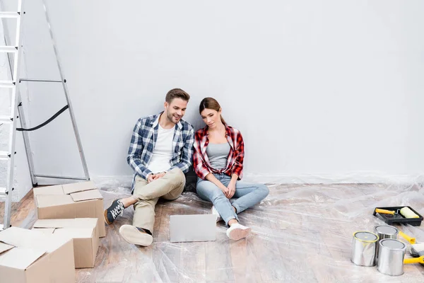 Comprimento Total Feliz Jovem Casal Olhando Para Laptop Enquanto Sentado — Fotografia de Stock