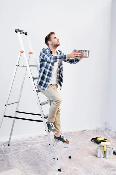 Full Length Young Man Looking While Holding Pot Standing Ladder — Stock Photo, Image