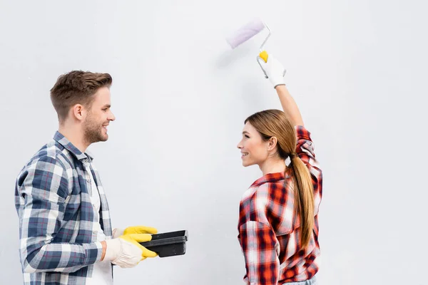 Lächelnde Junge Frau Mit Farbwalze Schaut Mann Der Tablett Isoliert — Stockfoto