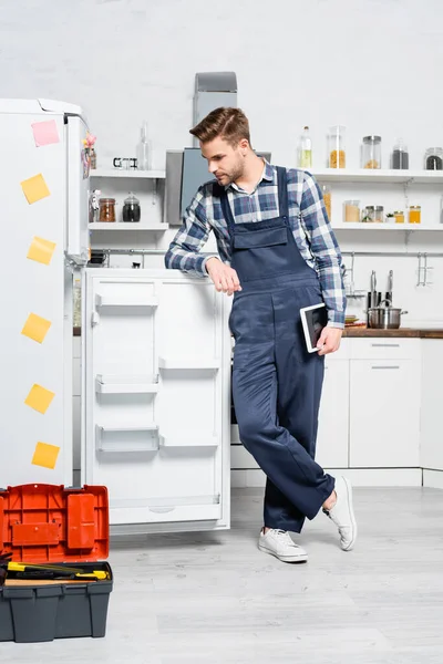 Lungimea Completă Tânărului Handyman Tabletă Uitându Frigider Bucătărie — Fotografie, imagine de stoc