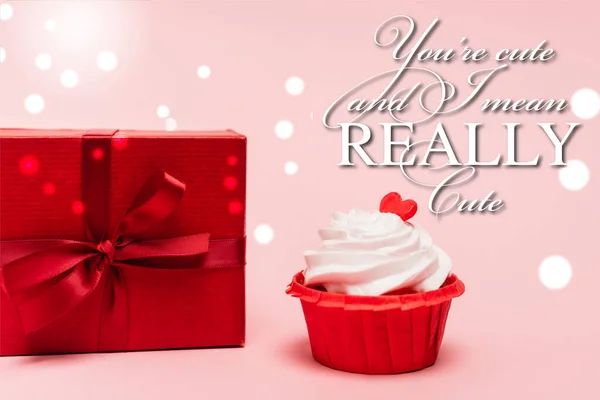 valentines cupcake with red heart near gift and you re cute and i mean really cute lettering on pink background