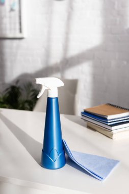 Masadaki bulanık arkaplan üzerine not defterlerinin yanındaki paçavra ve deterjan 