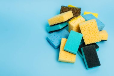 High angle view of yellow and blue sponges on blue background clipart