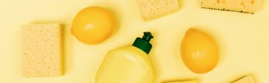 Sarı arka planda bulaşık deterjanı, taze limon ve sünger manzarası, afiş. 